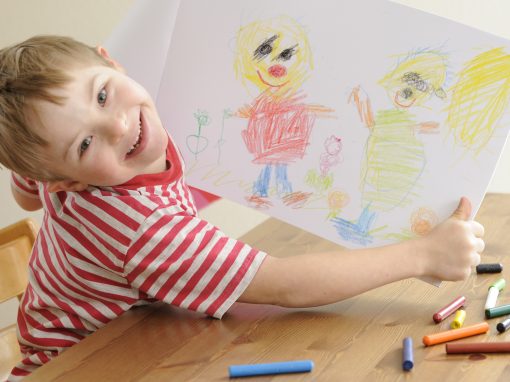 Boy with Down Syndrome shows his drawing